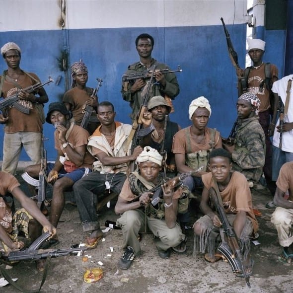 LIBERIA. Monrovia. June 25th, 2003. LURD fighters pose for the camera at the forward base in the Monrovian district of Duala by Tim Hetherington