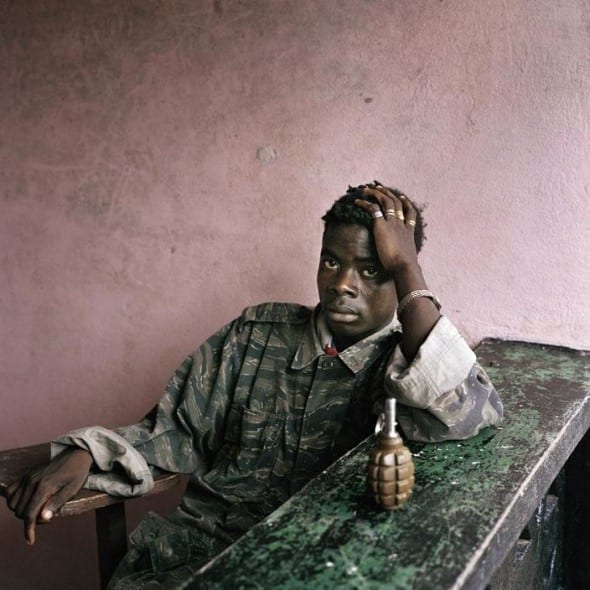 LIBERIA. Tubmanburg. June 16th, 2003. Young rebel fighter and hand grenade. by Tim Hetherington