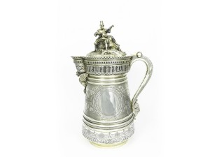 Monumentale tankard in argento Ivan Petrovich Khlebnikov, Mosca 1874 corpo interamente inciso con motivo di festoni di edera e rosoni, coperchio sormontato da gruppo scultoreo a tutto tondo raffigurante un contadino che suona la balalaika con una fanciulla accoccolata ai suoi piedi, beccuccio sorretto da gallo con ali spiegate gr 6394, h cm 43 Provenienza: Collezione del basso Boris Christoff Valutazione: 50.000,00 / 60.000,00 € Offerta di partenza: 50.000,00 €