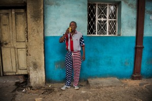 Un cubano indossa i colori della bandiera degli Stati Uniti e beve birra in una strada de L'Avana, Steve McCurry