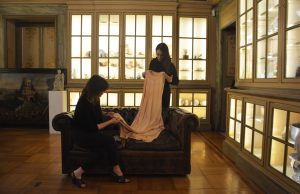 1. Roma, Palazzo Caetani Lovatelli: le esperte di Fashion, Luxury & Textiles di Bertolami Fine Arts al lavoro. In piedi, Ilaria De Santis, responsabile del dipartimento, Elisabetta Subrizi seduta e, al centro, un abito da sera fine anni ’30 di Madeleine Vionnet