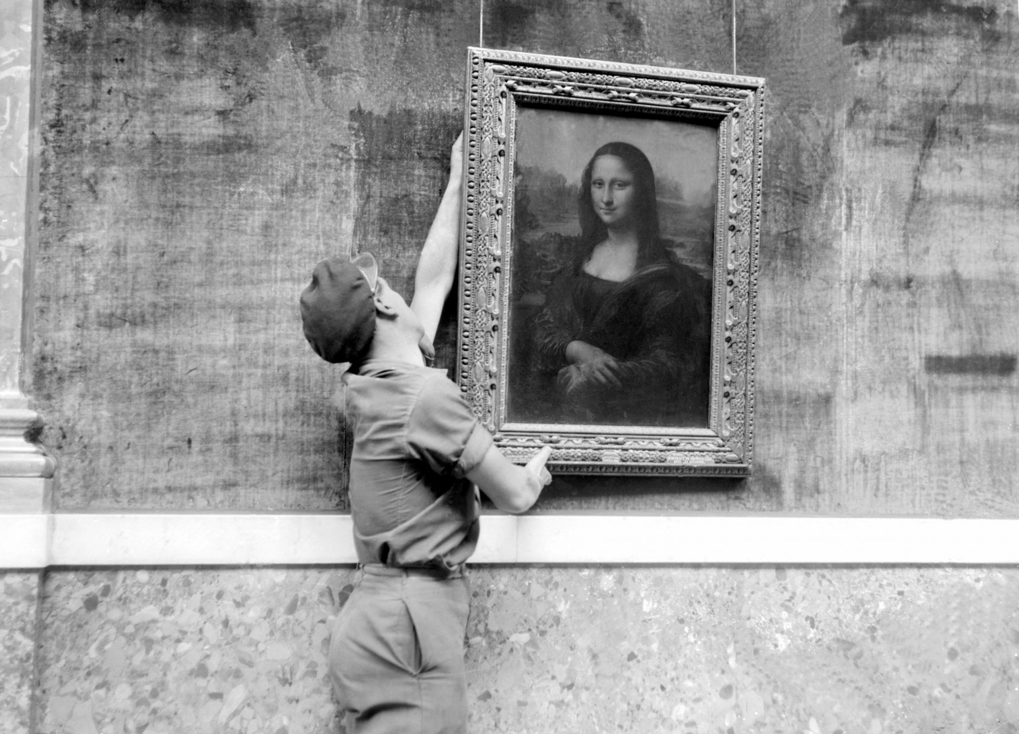 PARIS, FRANCE: An employee of the Louvre museum in Paris, France hangs the famous "Mona Lisa" painting, by Leonardo da Vinci, (1452-1519), 6 October 1947, during the re-opening of the Grand Gallery of the Louvre, which had been closed for two years following the end of World War II. AFP PHOTO (photo credit should read AFP/Getty Images)