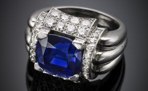 Lotto 977 WOLFERS FRERES Anello in platino, a nervature con zaffiro centrale a cuscino di ct. 9,40 circa rifinito con diamanti rotondi, g 20,68 misura 15/55. Accompagnato da analisi gemmologica SSEF n. 102552 del 26/09/2018, Basel Accompagnato da Analisi Gemmologica CISGEM n.11754 del 11/10/2018, Milano Stima € 130.000-180.000