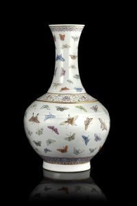 Lotto 1108 Vaso in porcellana Famiglia Rosa decorato con il motivo delle "cento farfalle", con corpo globulare, che sale da un piede dritto a un collo alto svasato al bordo, raffinatamente smaltato con il motivo delle "cento farfalle", diviso da un'ampia fascia di caratteri dorati shou intervallati da rametti di loto stilizzati, il bordo circondato da una fascia ruyi e il piede con pendenti su fondo turchese, la base con un marchio Guangxu a sei caratteri in rosso ferro Cina, dinastia Qing, periodo Guangxu (1875-1908) (h. 39,5 cm.) Stima € 10.000-12.000