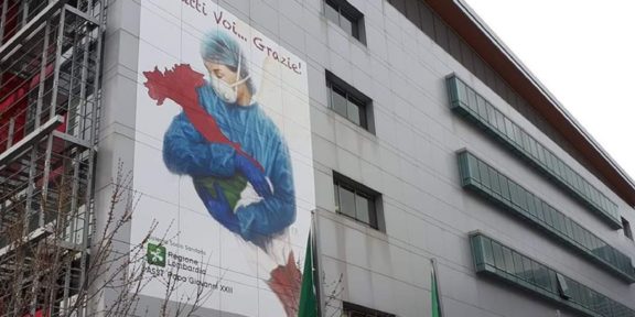 Muraòe Bergamo cin una dottoressa che culla l'Italia