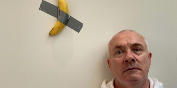 Damien Hirst con la replica della banana di Cattelan