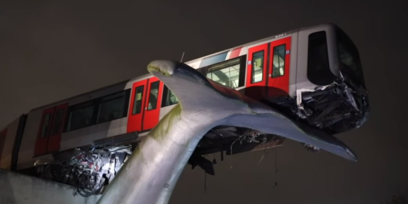 coda di una scultura di balena ferma convoglio di una metropolitana deragliato