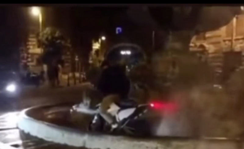 ragazzo con un motorino nella fontana delle rane del quartiere coppedè