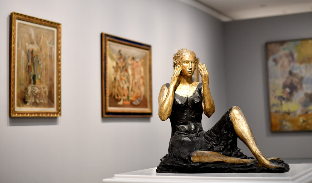 La Signorina seduta di Lucio Fontana e sullo sfondo opere di Giorgio De Chirico