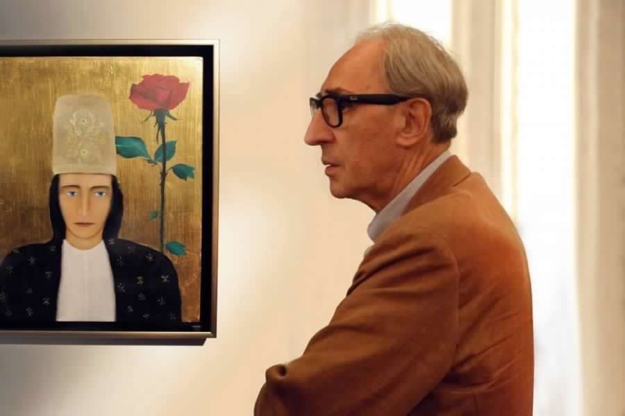 Franco Battiato al fianco del suo dipinto "Donna con rosa"