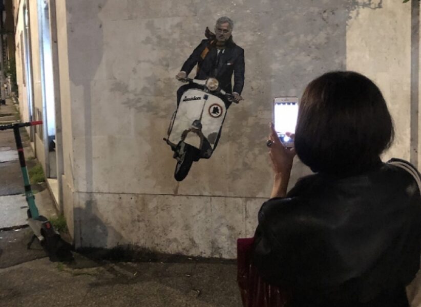 Ragazza scatta una foto al murale dedicato a Mourinho nel rione Testaccio di Roma