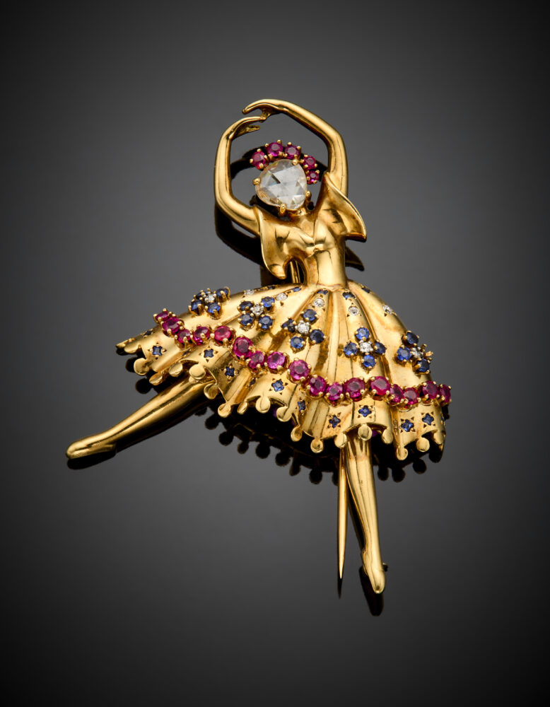 Lotto 101 Van Cleef & Arpels Broche "Ballerina" in oro giallo, il volto un diamante a mezza rosetta incorniciato da rubini, il tutù a frangia con diamanti, rubini e zaffiri, g 22,26 circa, lungh. cm 6,30 circa. Firmata e marcata Van Cleef & Arpels, n° 19119. Per confronto si veda: Alba Cappellieri 'Van Clle & Arpels. Il tempo, la Natura, l'amore' edizione Skira, pag. 162 e pag 165 Valutazione € 12.000 - 16.000