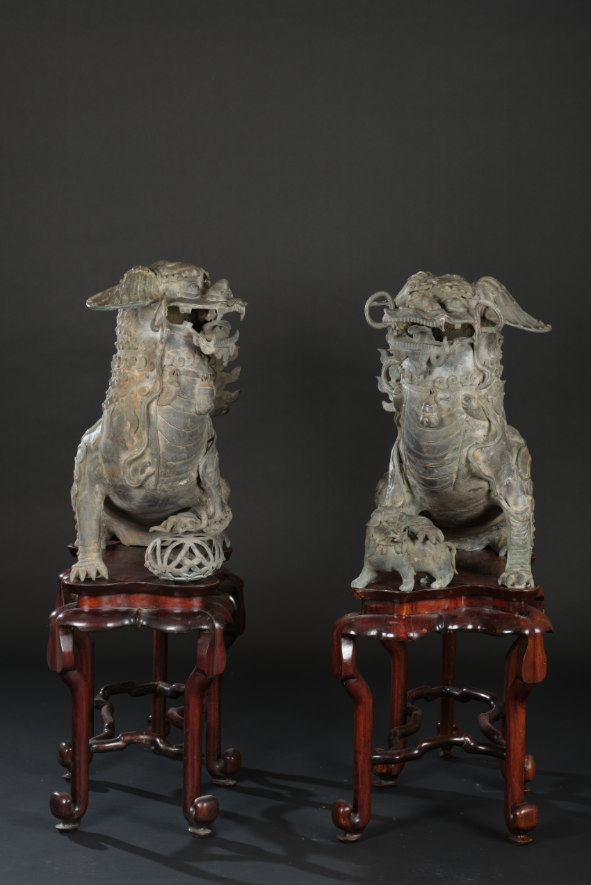 Rara coppia di grandi sculture in bronzo a foggia di cani di Pho su stand in legno di Homu, Cina, Dinastia Ming, XVI secolo cm 66x102x36; stand: h cm 56 Stima: 40.000 - 60.000 euro