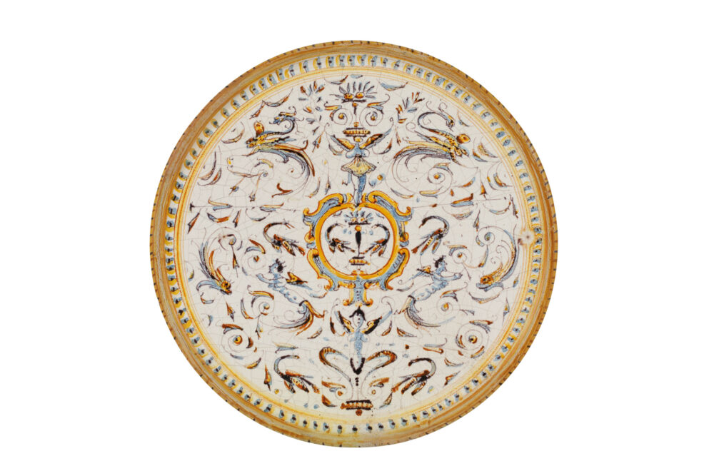 lotto 58** ALZATA IN MAIOLICA POLICROMA, BOTTEGA DI NICCOLO' SISTI, PISA, CIRCA 1600 con decoro a grottesche e cartiglio centrale; restauro al piede, poche usure e difetti Alt. cm 6, diam. cm 25 A PISA MAIOLICA TAZZA, CIRCA 1600; SLIGHTLY WORN Stima € 600 – 800