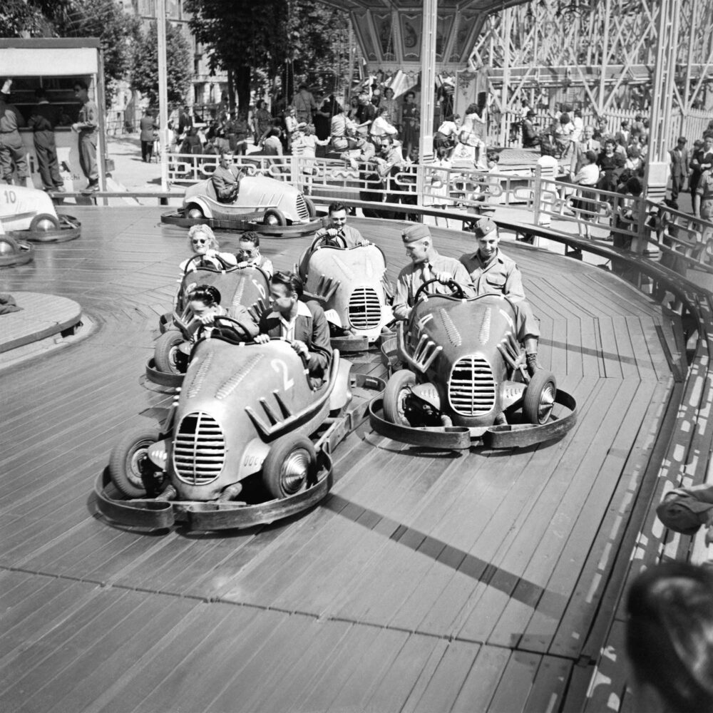 Militari e giovani sugli autoscontri del parco divertimenti di Porta Venezia, a Milano. 6 giugno 1945