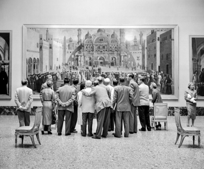 Un gruppo di turisti, in una delle sale della Pinacoteca di Brera, a Milano, ammira il dipinto “Predica di San Marco in una piazza di Alessandria d’Egitto” di Gentile e Giovanni Bellini. 6 luglio 1956 (Fotografia di Angelo Novi)