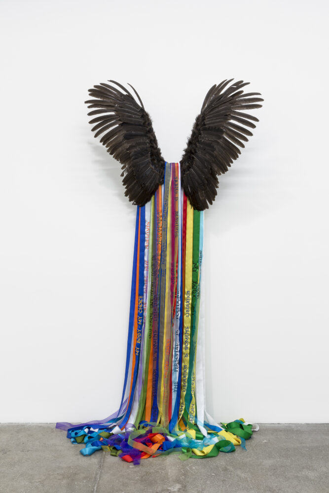 Andrea Bowers Goddess (Power of the Common Public ) , 2016 Feathers, metal bracket and ribbons 100 x 51 x 12 in (254 x 129.5 x 30.5 cm) Courtesy of the artist and Andrew Kreps Gallery , New York