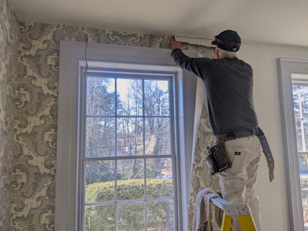 A worker installs wallpaper at the Emily Dickinson Museum in Amherst, Massachusetts. Photo: Patrick Fecher. Courtesy of the Emily Dickinson Museum.