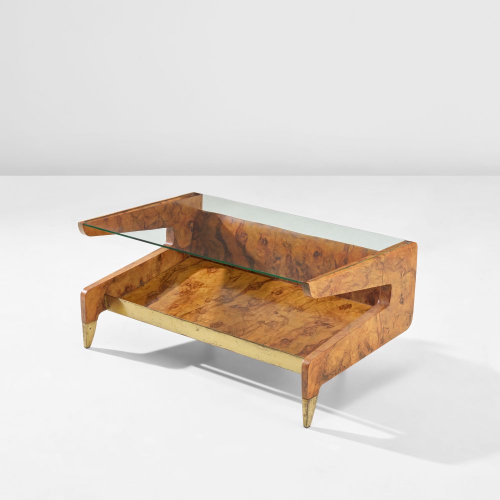 GIO PONTI 1891 - 1979 Coffee table, from Casa di Fantasia, Milan circa 1951 Burr walnut - veneered wood, burr - walnut, glass, brass. 40.6 x 89.3 x 49 cm (15 7/8 x 35 1/8 x 19 1/4 in.) Executed by Giordano Chiesa, Milan, Italy. Underside of glass top acid - etched PROTEX. Together with a certificate of expertise from the Gio Ponti Archives. ESTIMATE £40,000 - 60,000