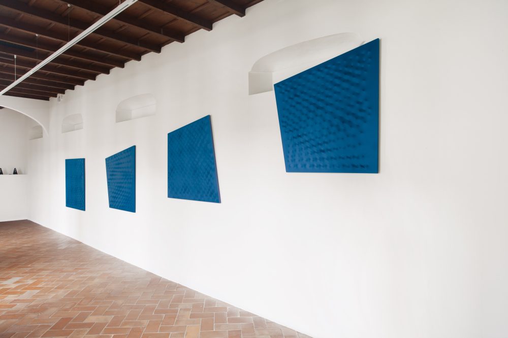 Veduta di una sala allestita al Museo d’arte Mendrisio con l’opera: Serie blu 1996 Acrilico su tela 120 × 120 cm ciascun elemento Enrico Castellani Estate