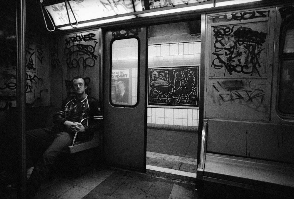 Tseng Kwong Chi Keith Haring, drawing in the subway, New York, circa 1983. Photo © Muna Tseng Dance Projects, Inc. Art © Keith Haring Foundation