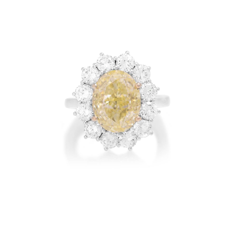 IMPORTANTE ANELLO. In oro bianco 18 kt, diamante Natural Fancy Yellow, taglio ovale di 6,04 ct, accompagnato da certificato gemmologico n° 6214510860 del 04/03/2021, GIA, Carlsbad, California, entro contorno in diamanti taglio brillante per tot. 2,70 ct ca. (prob. colore G/H, purezza VS). 9,50 g; misura 15. base d’asta: 40.000 €