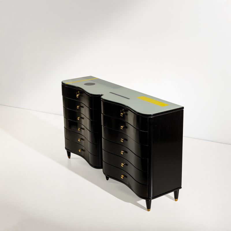 Lotto 72 LUCIO FONTANA & OSVALDO BORSANI Cassettiera. Legno di noce ebanizzato, legno di acero, ottone, cristallo molato retro dipinto ad aerografo e tecnica mista. Firma dell'artista incisa sul retro del piano. Esecuzione Arredamenti Borsani Varedo, 1955 ca. Il presente lotto è corredato da certificazione dell' Archivio Osvaldo Borsani ed è in corso di archiviazione da parte della Fondazione Lucio Fontana che lo ha esaminato e giudicato autografo. cm 91x155x41 Stima € 80.000 - 120.000
