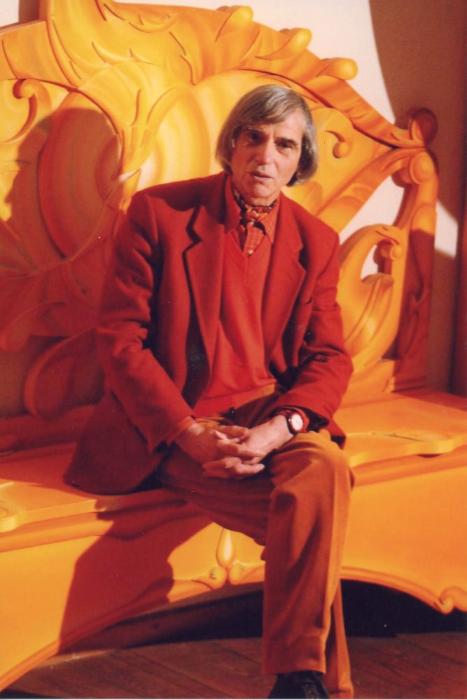 Notari in studio seduto sulla panca da lui dipinta