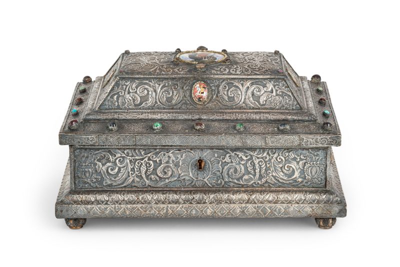 Lotto 252Scrigno in argento, legno, smalti e pietre, mosca, 1896-1908, orafo P. Milukov A quattro piedini, sezione rettangolare, coperchio a doppio livello, superficie decorata a motivi naturalistici, arricchita da pietre cabochon e cinque medaglioni in smalto; difetti. Alt. cm 24, larg. cm 43, prof. cm 32; peso lordo gr 6300. Aggiudicazione: € 30.150 Wannenes