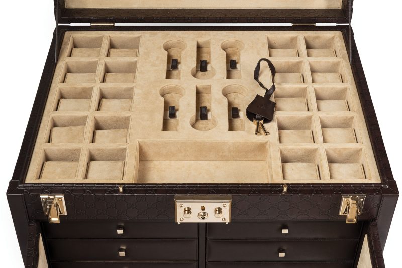 Lotto 500GUCCI Importante cofanetto portagioie e orologi in pelle Guccissima marrone scuro. Periodo: Direzione creativa di Frida Giannini, 2006-2014. Materiali: Legno massello, pelle Guccissima goffrata, interno effetto pelle scamosciata, metallo dorato. Colori: Marrone scuro, beige e oro. Dimensioni: 62 x 50 x 55 cm. Aggiudicazione: € 15.240 Wannenes